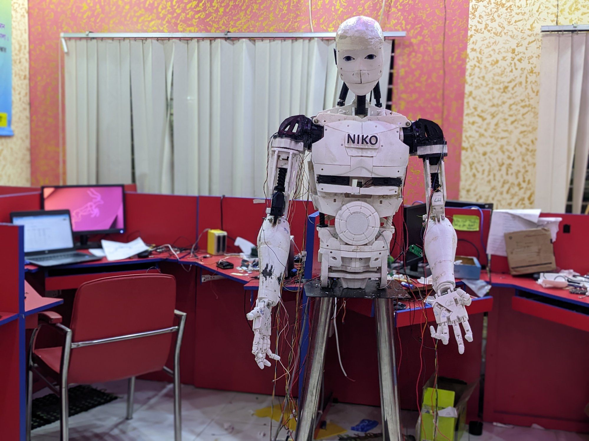 Robot Niko, finished: a white 3D-printed humanoid head, torso, arms and hands on a stand, with NIKO printed on its chest.